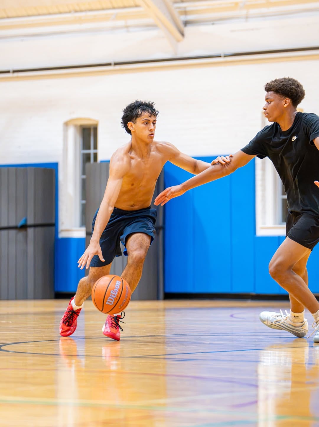 Player driving past a defender during a We All Hoop session